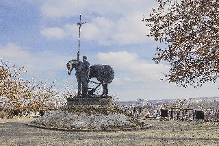 Памятник «Первопоселенец» с деревянной звонницей